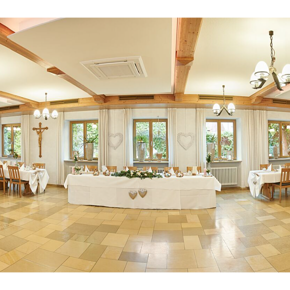 Speisesaal des Landgasthof Euringer Der große, helle Speisesaal ist festlich gedeckt. Die Tische stehen in Reihen. Auch die helle, hohe Decke ist zu sehen.